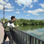 a man standing on a bridge over a body of water