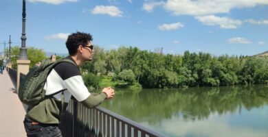 a man standing on a bridge over a body of water